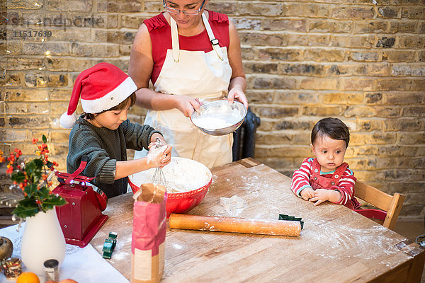 Mutter und Sohn backen zu Hause Weihnachtsplätzchen