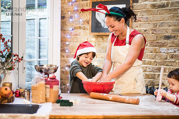 Mutter und Sohn backen zu Hause Weihnachtsplätzchen