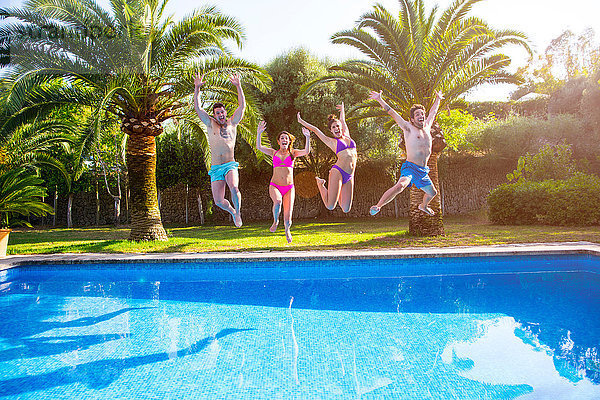 Freunde springen im Schwimmbad