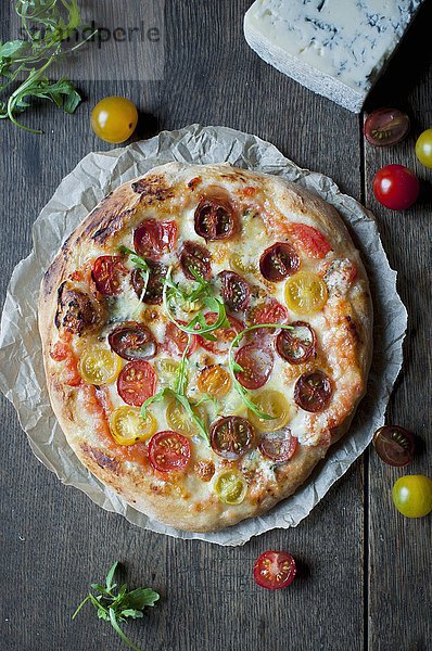 Hausgemachte Pizza  belegt mit bunten Kirschtomaten  Mozzarella und Gorgonzola