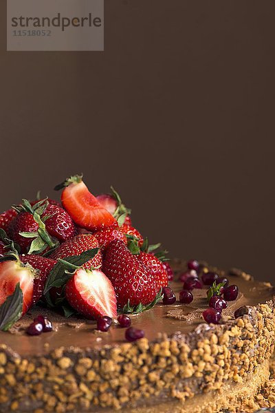 Ein Schokoladenkuchen mit Erdbeeren  Granatapfelkernen und Nüssen