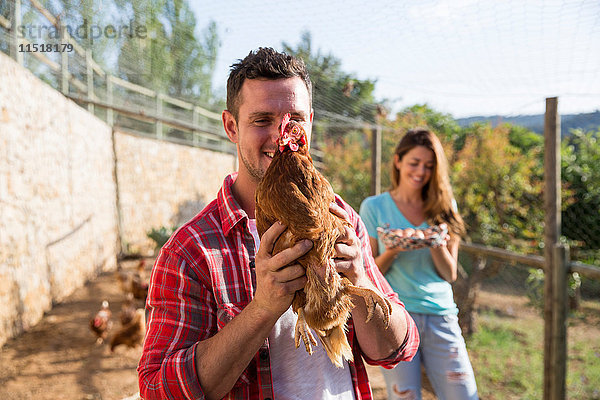 Porträt eines Biobauern mit freilaufenden Hühnern