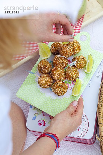 Fischbällchen mit Staudensellerie  Zwiebeln und Sesam für ein Strandpicknick