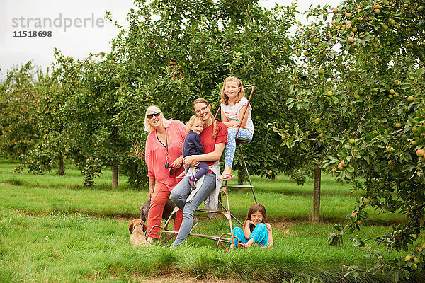 Familie auf Trittleiter im Apfelgarten