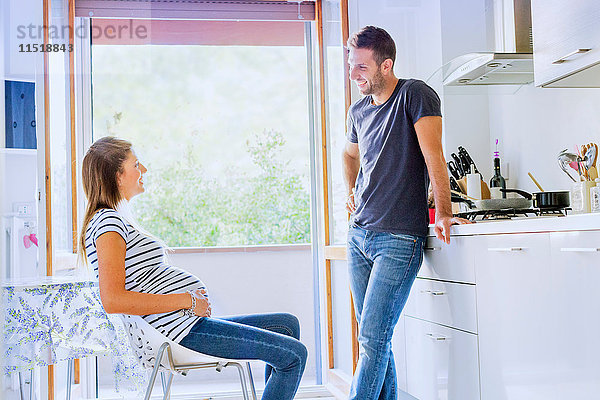 Schwangeres Paar in der Küche im Gespräch