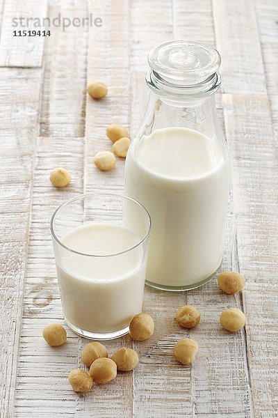 Macadamia-Milch in einer Flasche und einem Glas