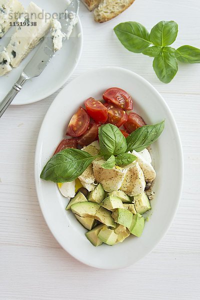 Tomate  Mozzarella und Avocado mit Basilikum