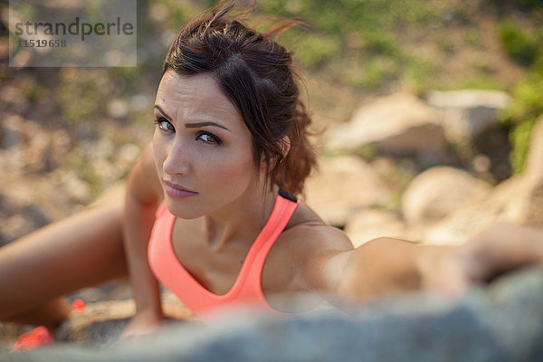 Junge Frau beim Sport im Freien  Klettern an Felsen  erhöhte Aussicht