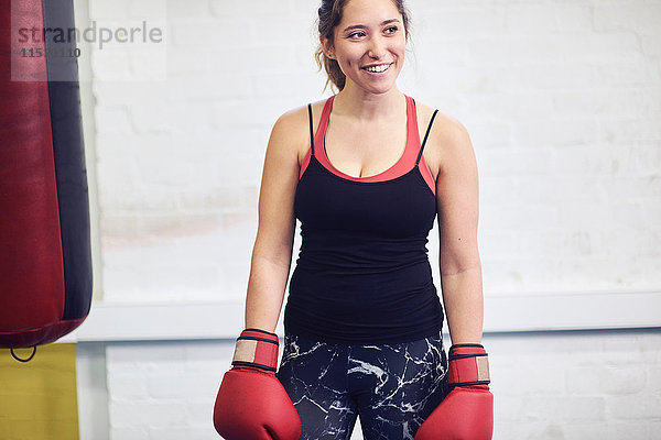 Junge weibliche Boxerin trägt rote Boxhandschuhe