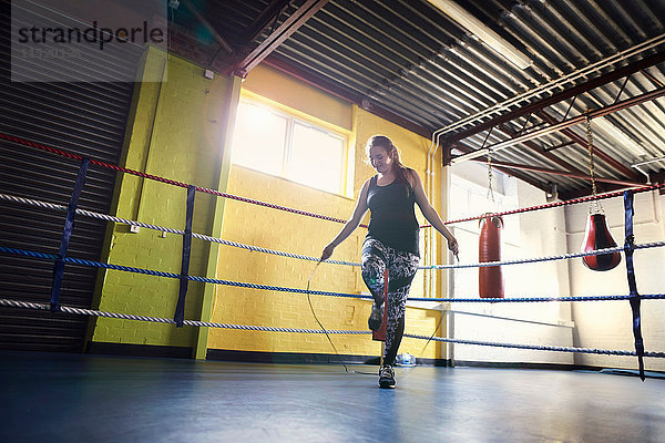 Junge Boxerin springt im Boxring