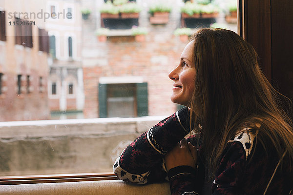 Frau schaut aus dem Fenster  Venedig  Italien