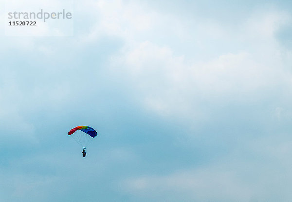 Fernsicht eines Fallschirmspringers vor bewölktem Himmel