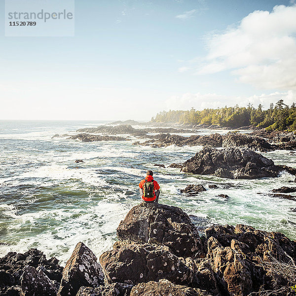 Männlicher Wanderer  der von der Felsküste aufs Meer hinaussieht  Wild Pacific Trail  Vancouver Island  Britisch-Kolumbien  Kanada