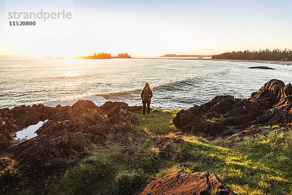 Frau beobachtet Sonnenuntergang von der Küste aus  Pacific Rim National Park  Vancouver Island  British Columbia  Kanada