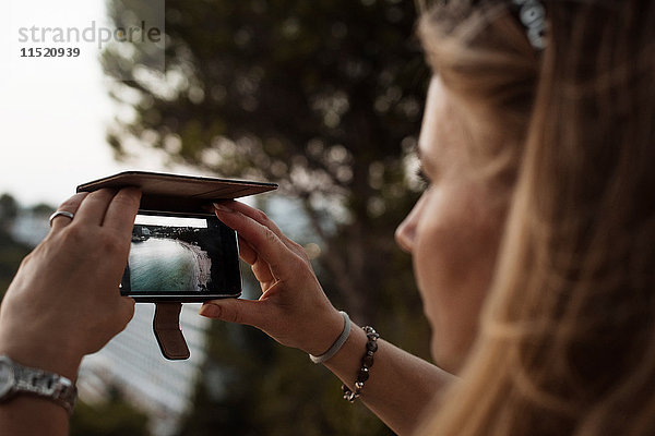 Frau  die mit einem Smartphone fotografiert  Menorca  Spanien