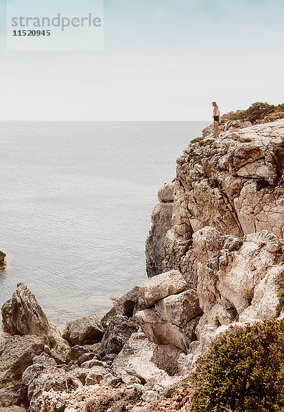 Auf einer Klippe stehende Frau  Menorca  Spanien