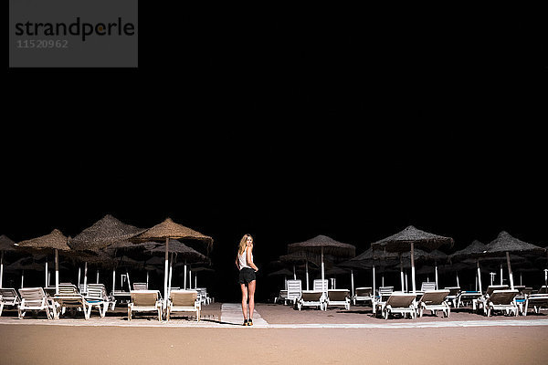 Frau auf Liegestühlen am nächtlichen Strand  Fuengirola  Spanien