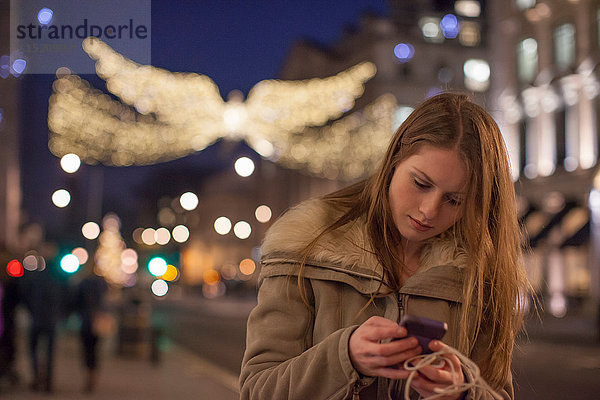 Junge Frau mit Handy in der Straße  London  UK