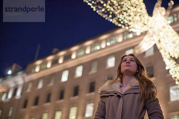 Junge Frau genießt Weihnachtsbeleuchtung  Regent Street  London  UK