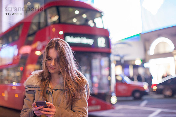 Junge Frau mit Handy in der Straße  London  UK