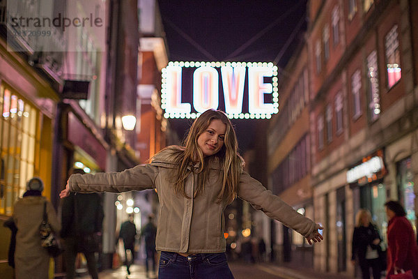 Junge Frau genießt Weihnachtsbeleuchtung  Carnaby Street  London  UK