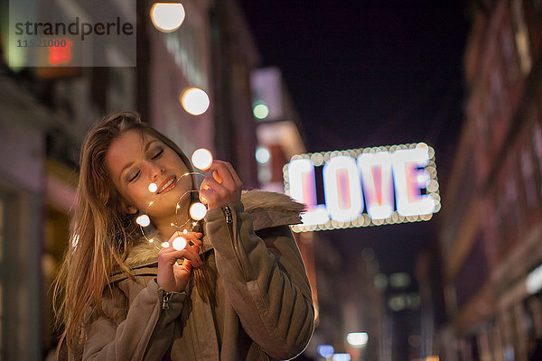 Junge Frau genießt Weihnachtsbeleuchtung  Carnaby Street  London  UK