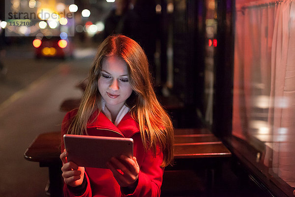 Junge Frau mit digitalem Tablett in der Straße  London  UK