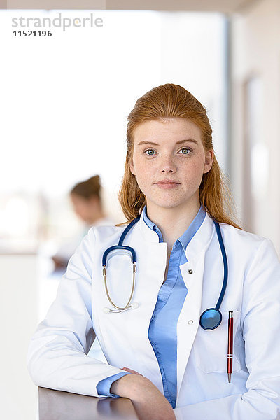 Porträt einer rothaarigen jungen Ärztin im Krankenhaus