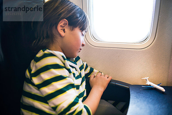 Junge im Flugzeug schläft im Flugzeugsitz