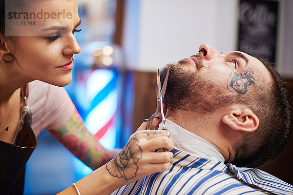 Friseur schneidet Kunden den Bart