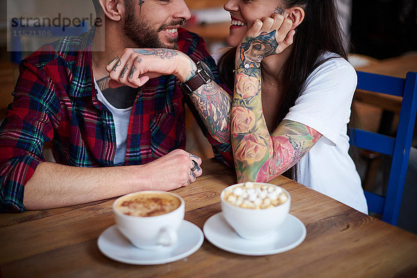 Paar im Café von Angesicht zu Angesicht lächelnd