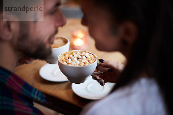 Paar im Café von Angesicht zu Angesicht lächelnd