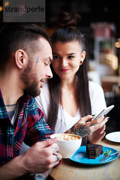 Paar mit Smartphone im Cafe