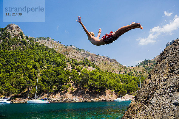 Junger Mann taucht ins Meer  Cala Tuent  Mallorca  Spanien