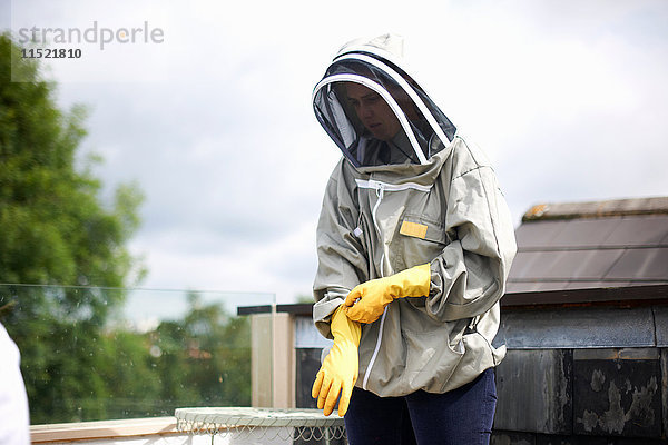 Imker im Bienenanzug  Vorbereitung zur Inspektion des Bienenstocks