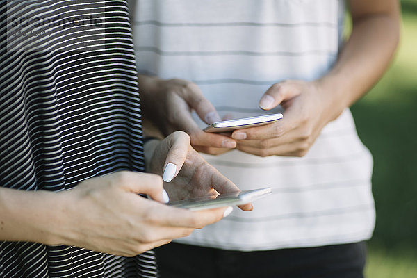 Hände von jungen Frauen mit Smartphones
