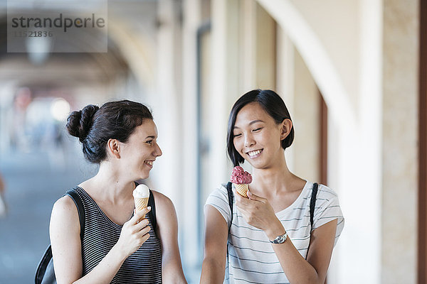 Zwei lächelnde junge Frauen mit Eistüten
