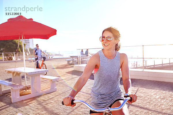 Frau fährt Fahrrad auf der Promenade