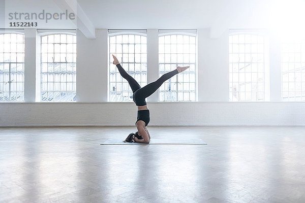 Frau im Tanzstudio beim Kopfstand