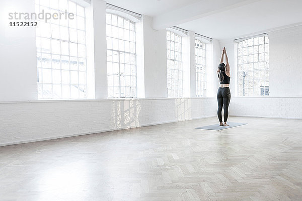 Rückansicht einer Frau im Tanzstudio beim Stretching