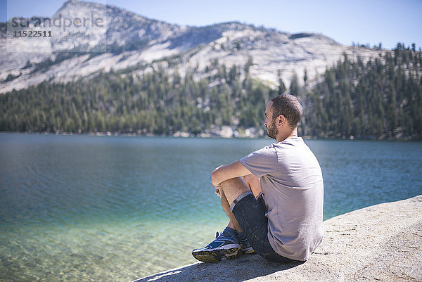 USA  Kalifornien  Yosemite Nationalpark  Mann am Bergsee sitzend