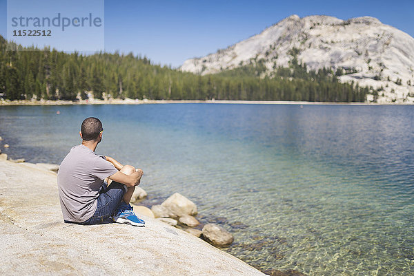 USA  Kalifornien  Yosemite Nationalpark  Mann am Bergsee sitzend