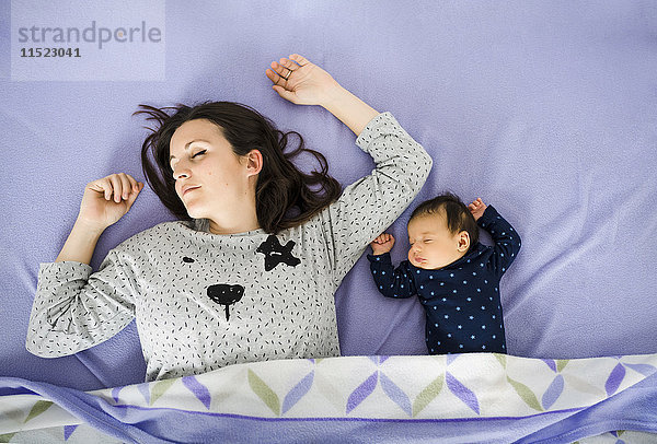 Neugeborenes Mädchen und Mutter schlafen im Bett
