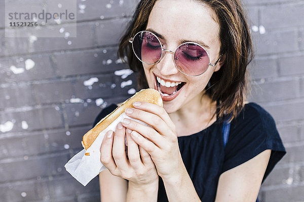 Porträt einer Frau  die einen Hot Dog isst