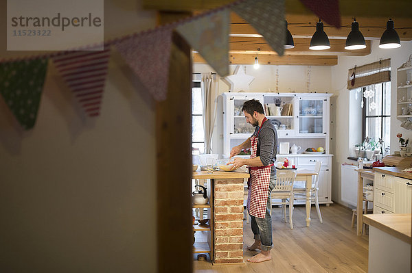 Mann in der Küche stehend  Kuchenteig zubereitend