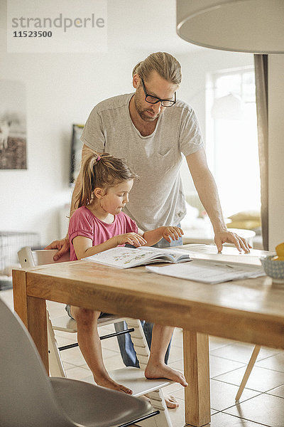 Vater prüft Hausaufgaben seiner Tochter
