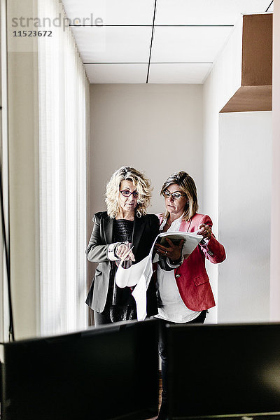 Zwei Geschäftsfrauen arbeiten gemeinsam an Dokumenten im Büro