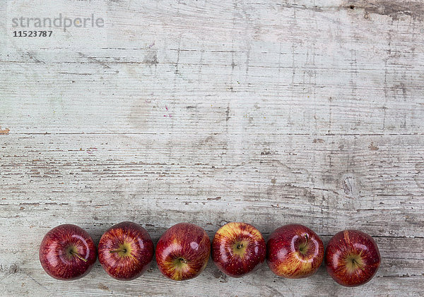 Reihe von sechs roten Äpfeln
