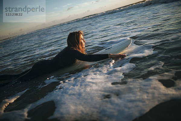 Frau auf dem Surfbrett im Meer liegend