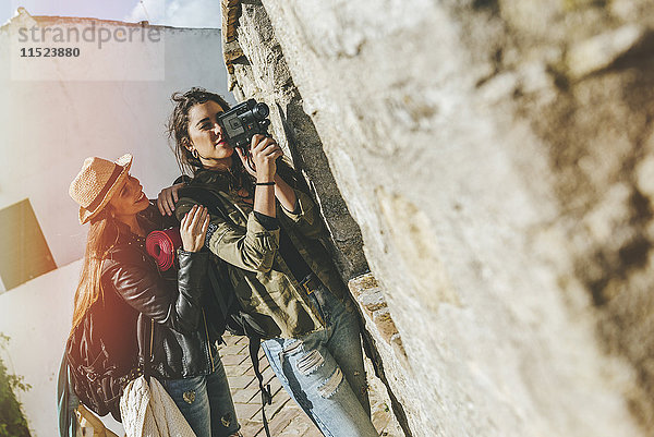 Junge reisende Frauen beim Aufnehmen mit alter Videokamera